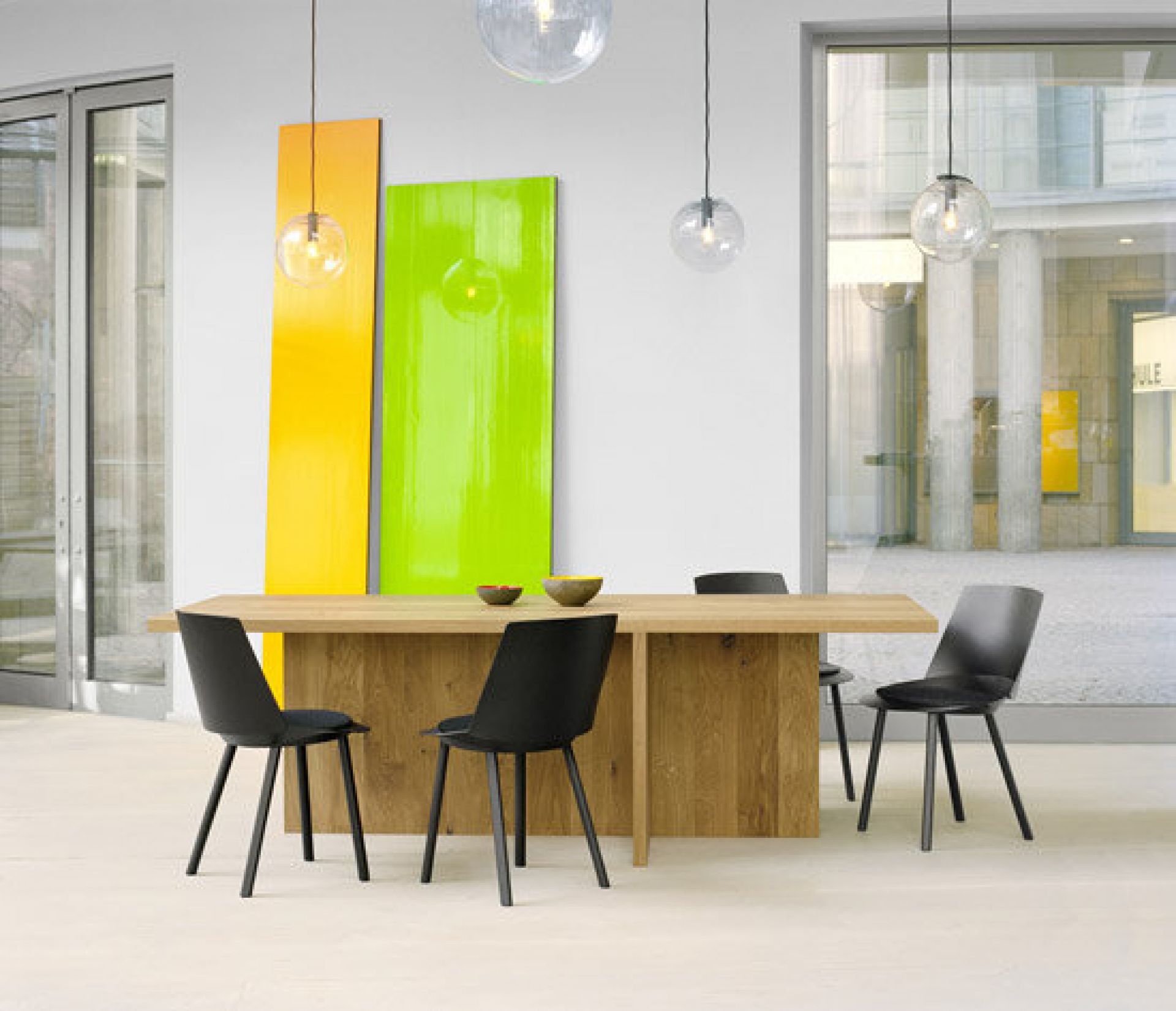 TA18 Zehn Esstisch von e15: Massiver Eichentisch mit schwarzen Stühlen in modernem Interieur.