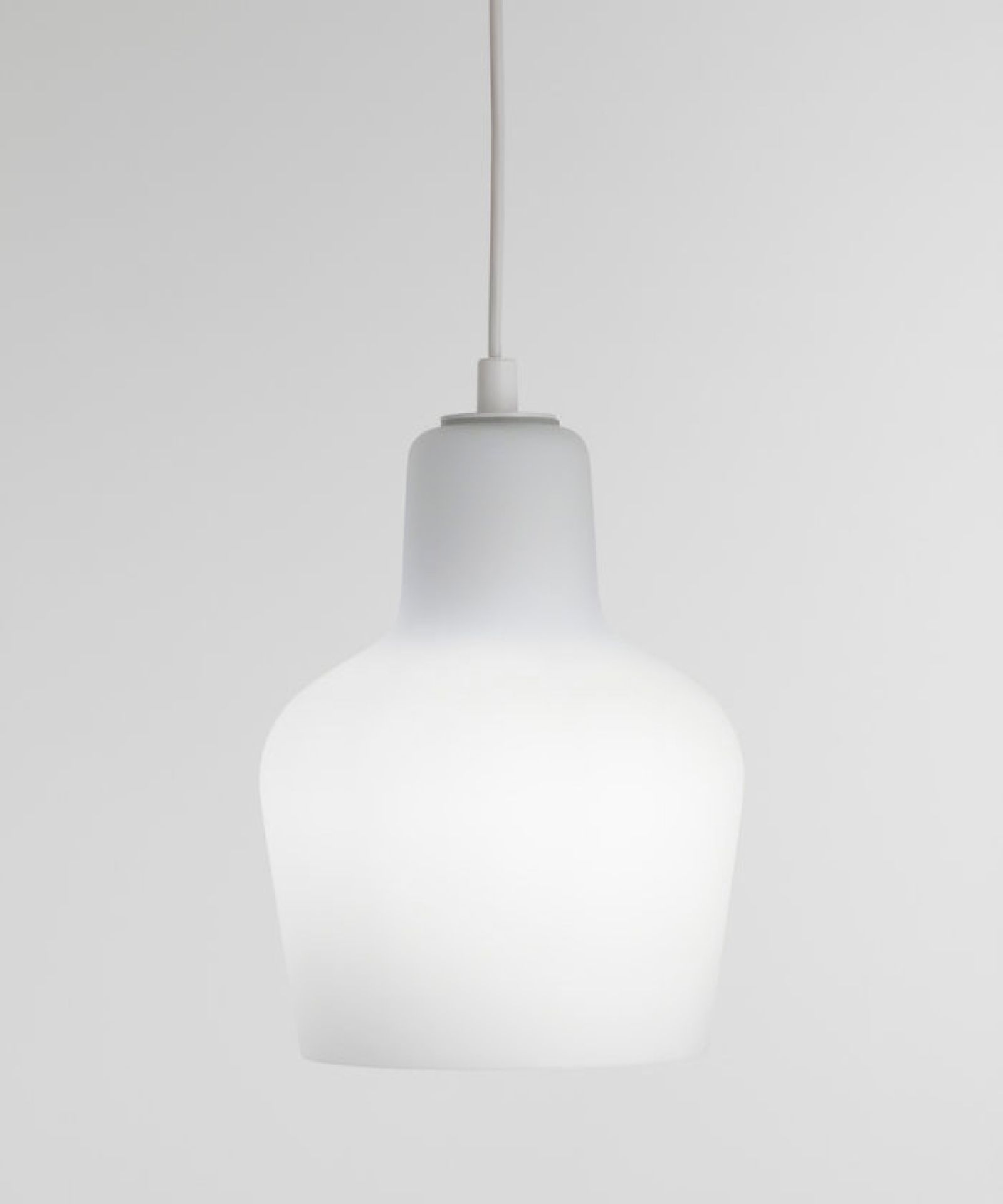 Weiße A440 Hängeleuchte von Artek mit sanftem Lichtschein vor neutralem Hintergrund. Design Lampe für Wohnräume.