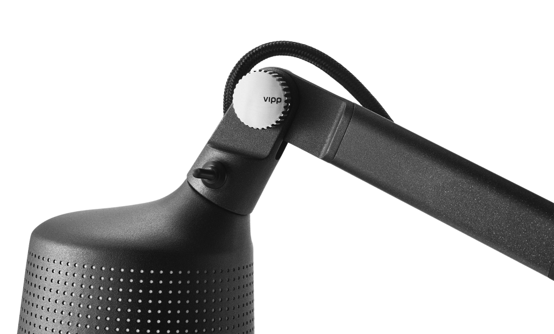 Nahaufnahme der schwarzen Vipp Wandlampe mit verstellbarem Arm und gelochtem Lampenschirm.