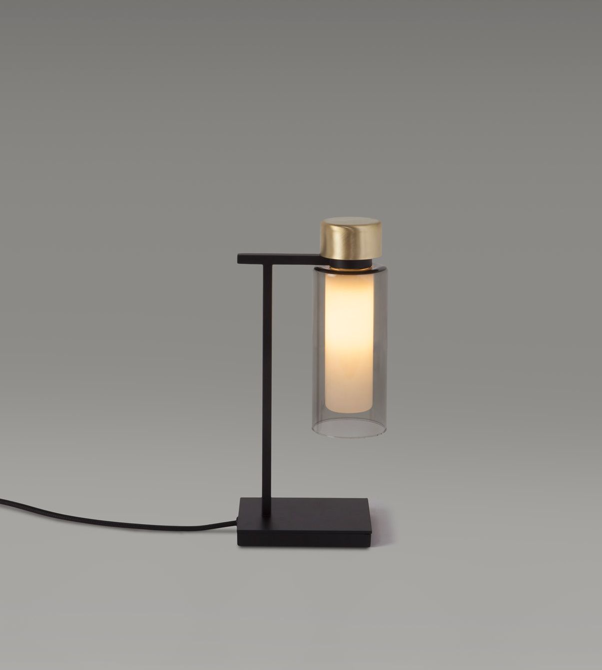 Osman Tischleuchte von Tooy: Moderne Nachttischlampe mit Glaszylinder und goldfarbenem Akzent.