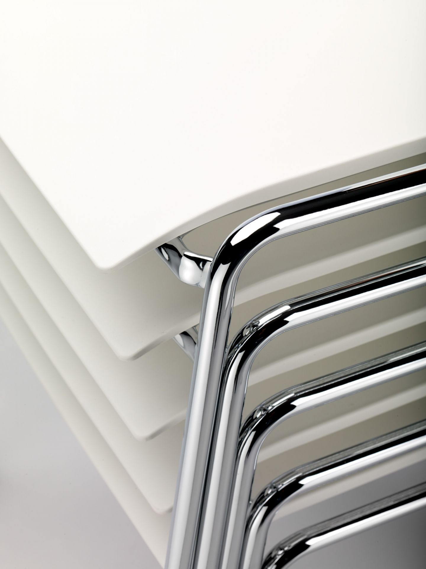 Detailaufnahme von gestapelten, weißen S 260 Stühlen ohne Armlehne von Thonet mit verchromtem Stahlrohrgestell.