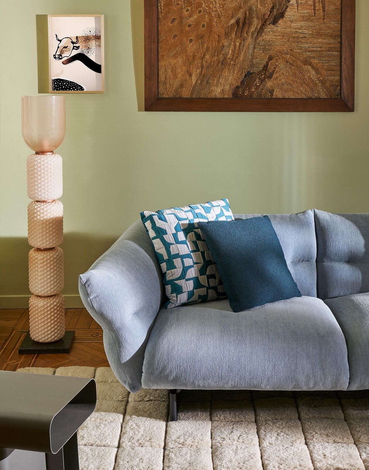 Helles Wohnzimmer mit Moncloud Sofa, blauen Kissen und moderner Stehlampe. Cassina Designmöbel.