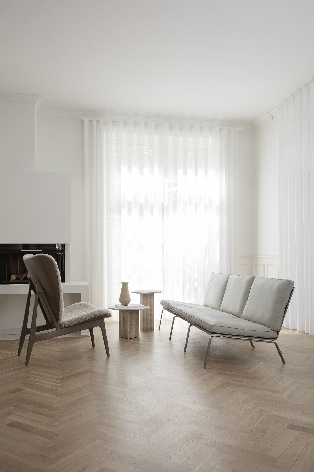 Helles Wohnzimmer mit NORR11 Soho Couchtisch, Sessel und Sofa auf Parkettboden. Minimalistisches Design.