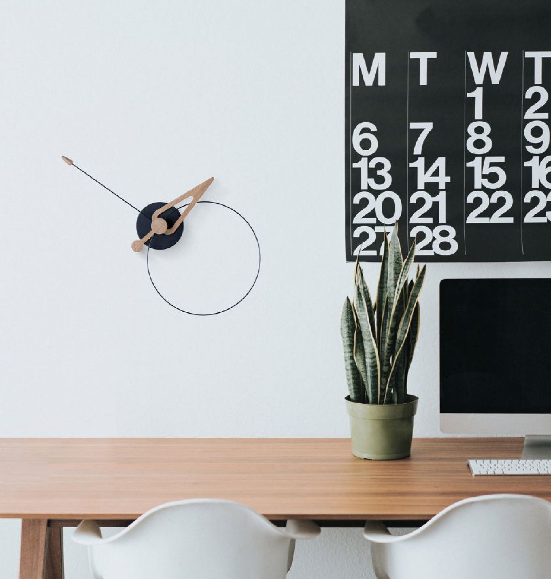 Moderne Pico Wanduhr von Nomon im minimalistischen Design mit Holzzeigern und schwarzem Zifferblatt.