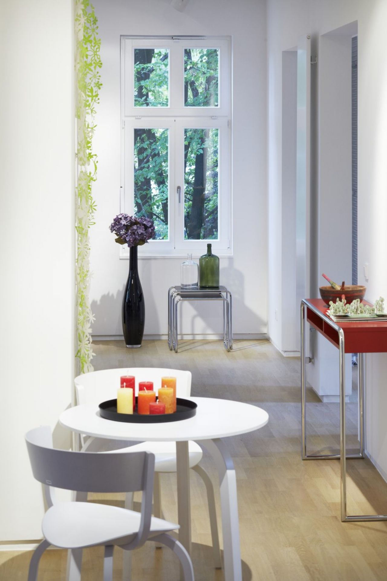 Heller Raum mit Thonet B 108 Konsolentisch in Rot und weiteren Designmöbeln.