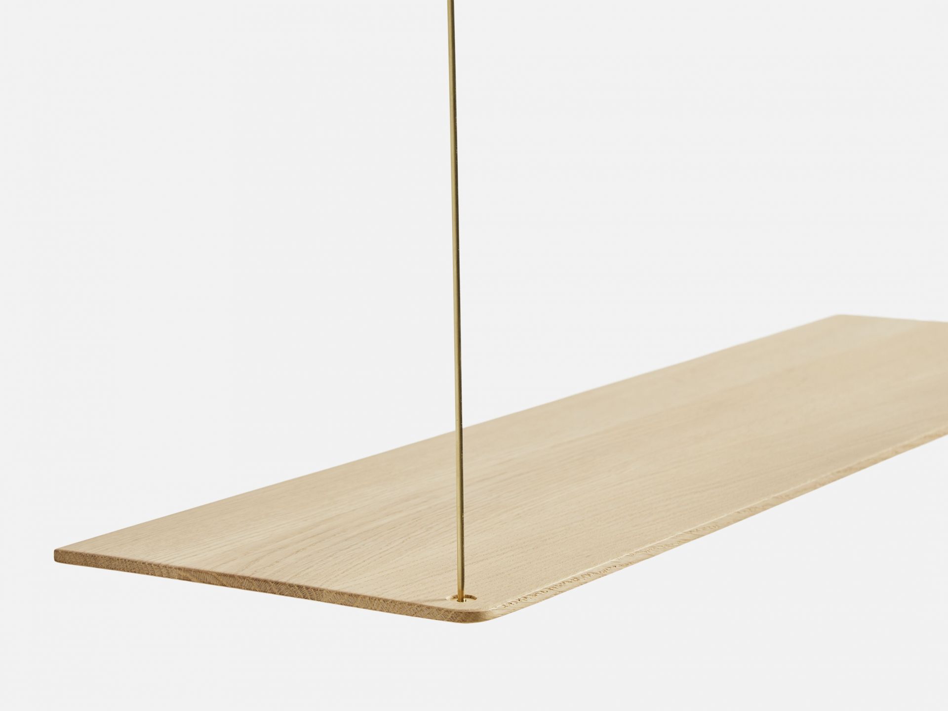 Detailaufnahme eines hellen Stedge Add-on Regalbords aus Holz mit goldener Aufhängung.