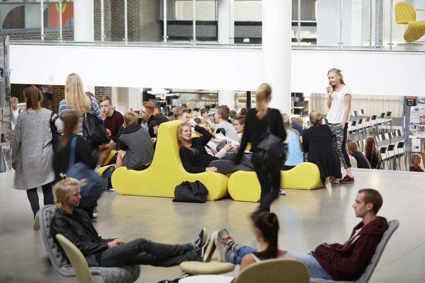 Gelbes Welle 1 Sofa von Verpan mit zwei Sitzen in einer modernen, öffentlichen Wartehalle.