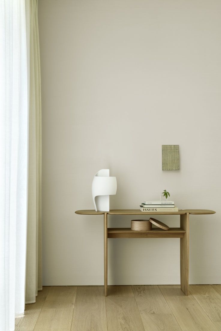 Ethnicraft Konsole aus Eiche: Elegante Holzkonsole mit Ablage, dekoriert mit Lampe, Büchern und Box.