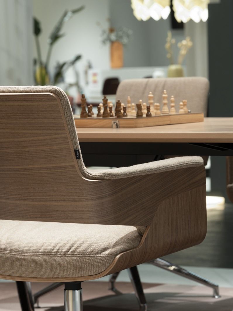 Detailaufnahme des Thonet S 847 PVD Drehsessels mit Holzschale und beigem Stoffbezug. Bürostuhl für stilvolles Arbeiten.