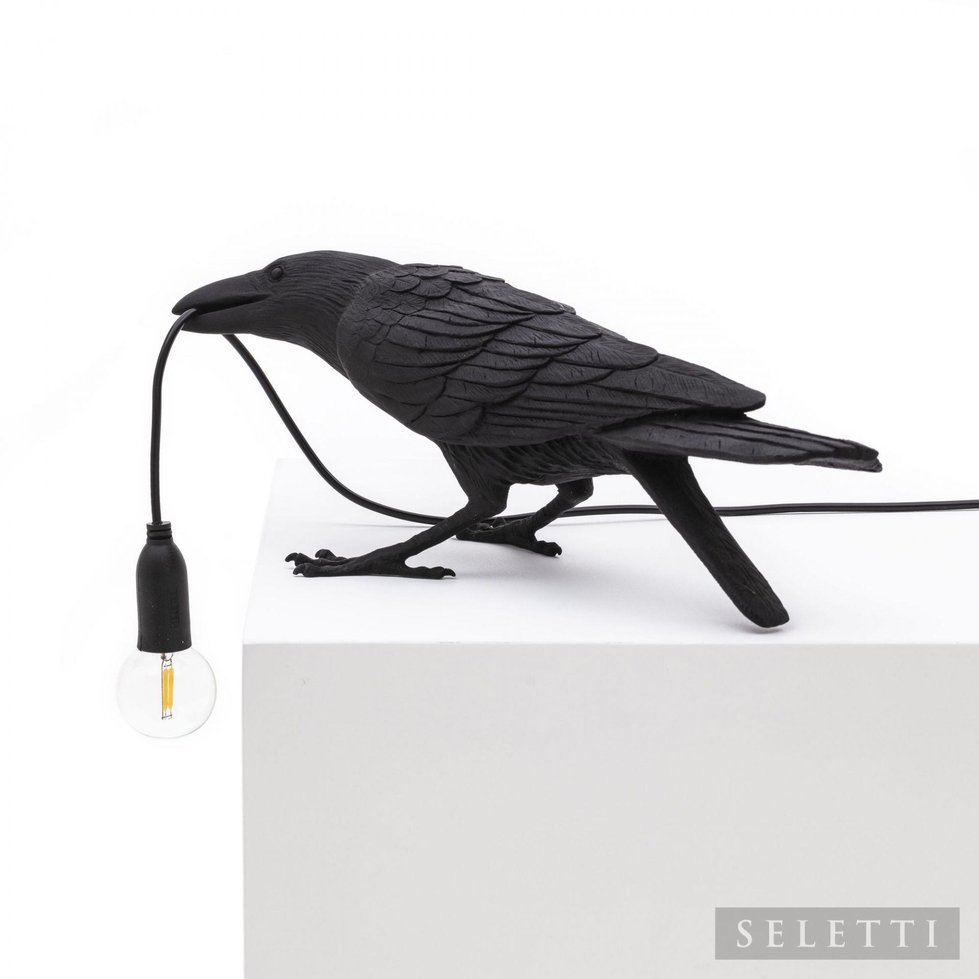 Schwarze Seletti Bird Lamp Playing Leuchte in Form eines Raben mit Glühbirne im Schnabel.