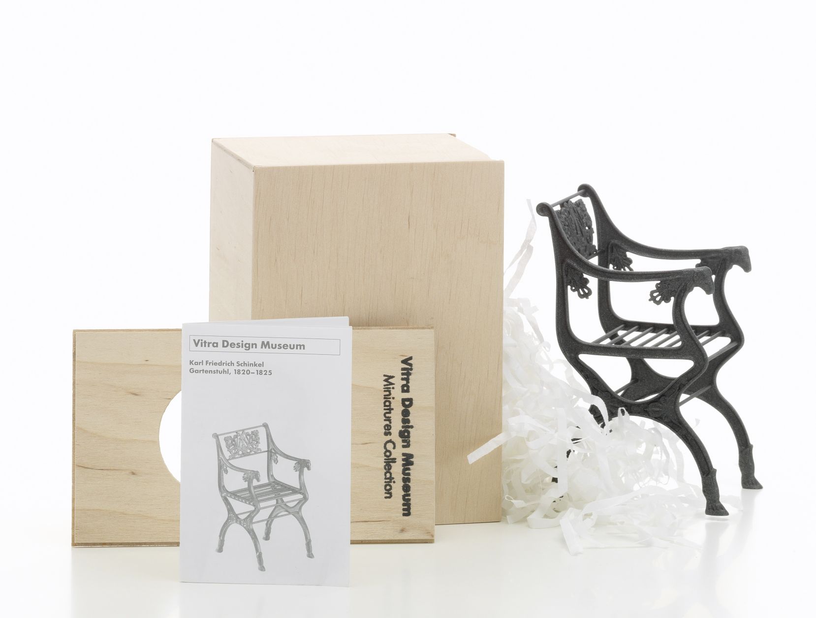 Detailaufnahme: Schwarzer Vitra Gartenstuhl [1820] Miniatur, mit Verpackung und Produktinformationen, Designmöbel für Sammler.