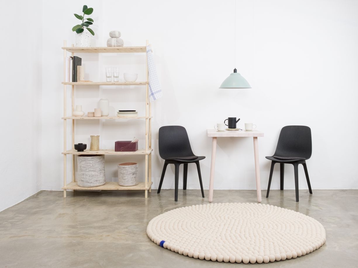 Beiger, runder Filzteppich "Big One" von myfelt (Ø 200cm) im minimalistischen Wohnraum.