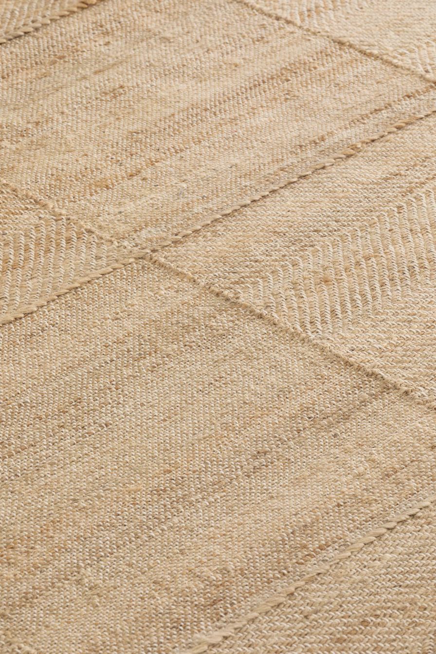 Detailaufnahme des Roots Teppichs von Gan, ein beiger Teppich aus Naturfasern mit Muster.