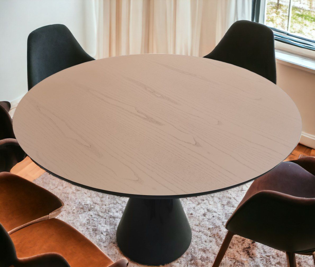 Runder Pion Esstisch mit heller Tischplatte und schwarzem Fuß, umgeben von Stühlen.