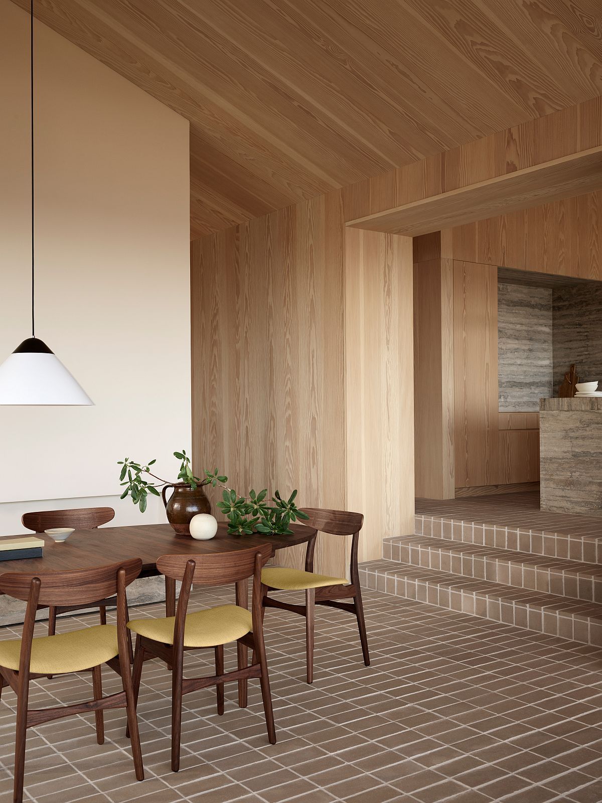 Helle HJW38 Opala Pendelleuchte von Carl Hansen & Søn über einem Holzesstisch mit Stühlen.