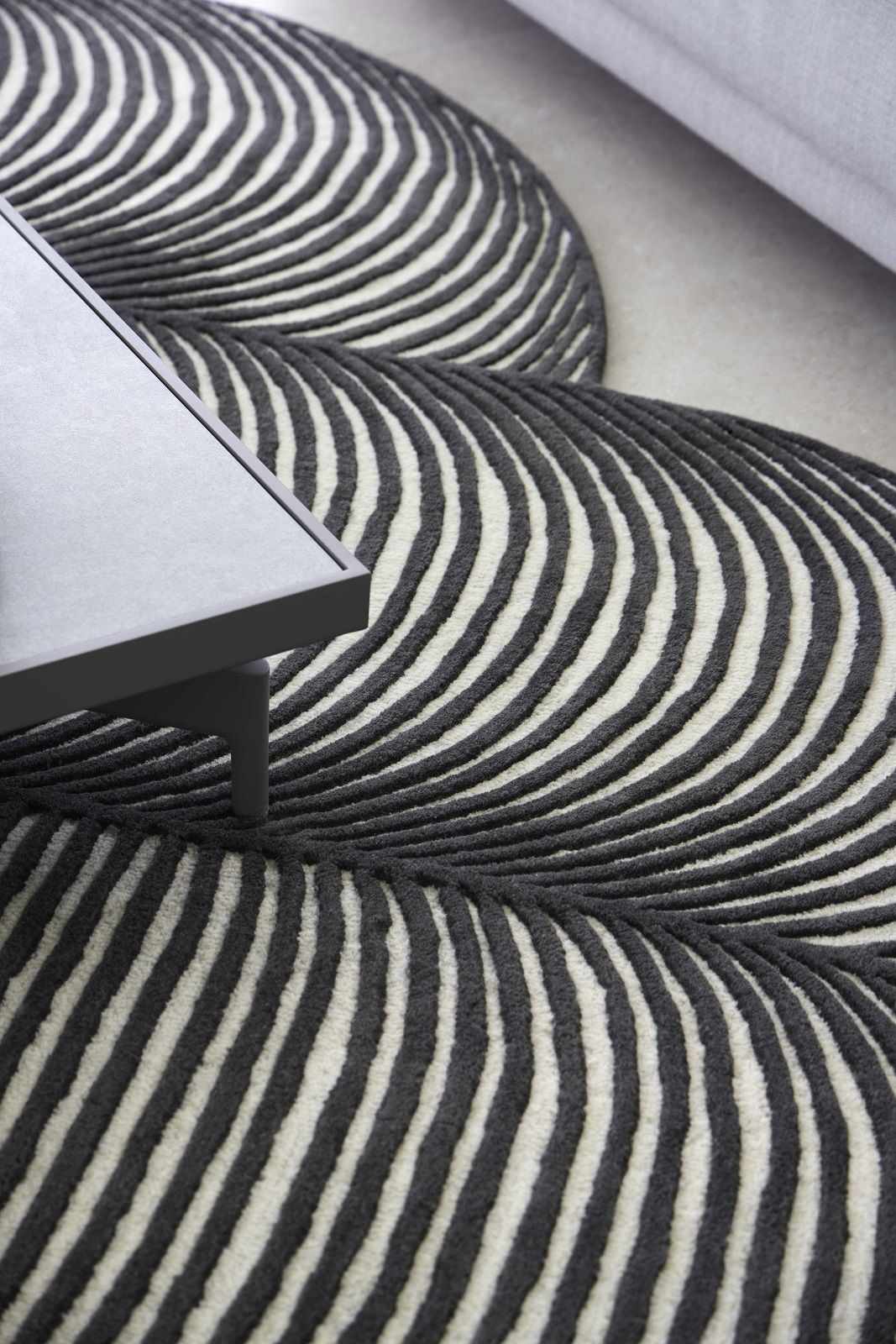 Detailaufnahme des Giro Teppichs von Gan mit abstraktem, gestreiftem Muster in Grau und Weiß.