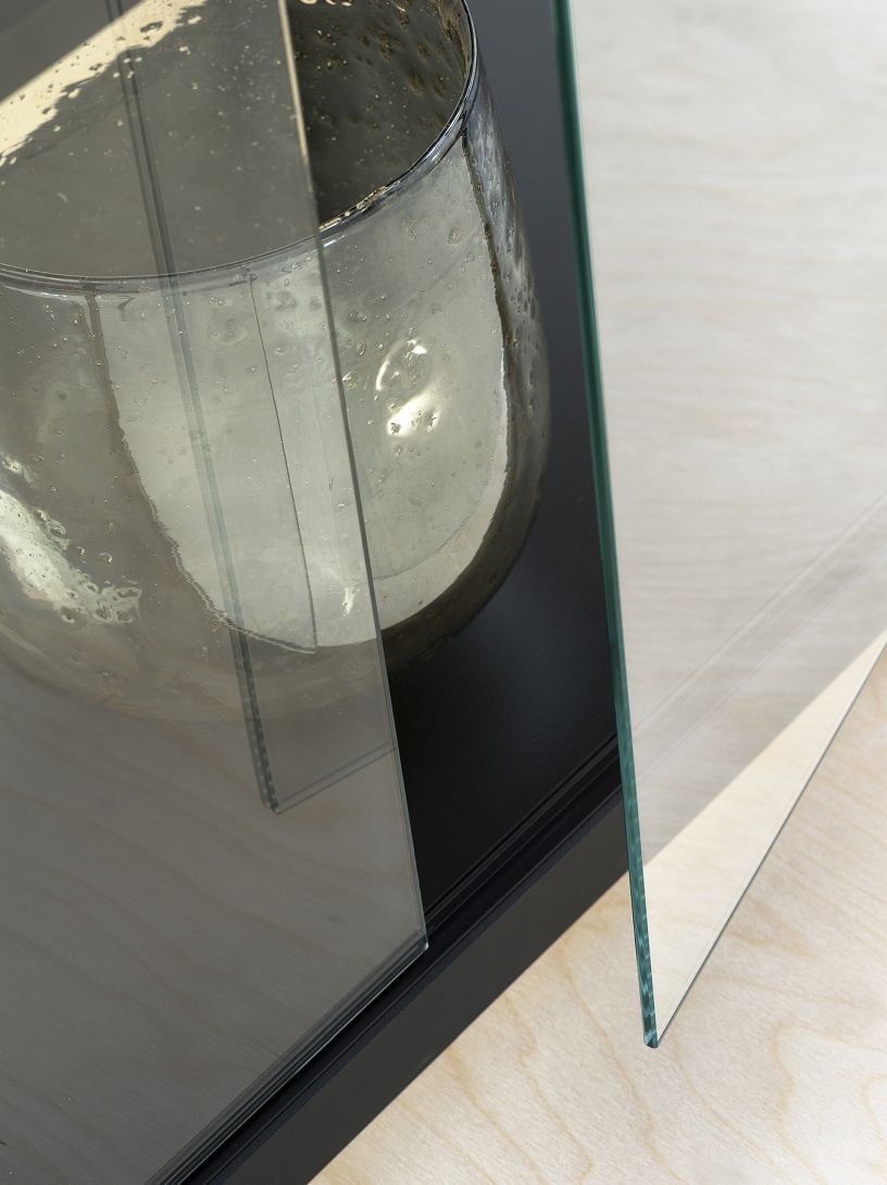 Detailaufnahme der Stolp Vitrine mit Glasböden und einer dekorativen Vase.