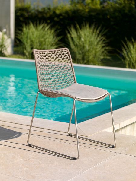 Weishäupl Slope Chair Outdoor Stuhl mit hellgrauem Sitzkissen vor Pool. Gartenmöbel für Terrasse.