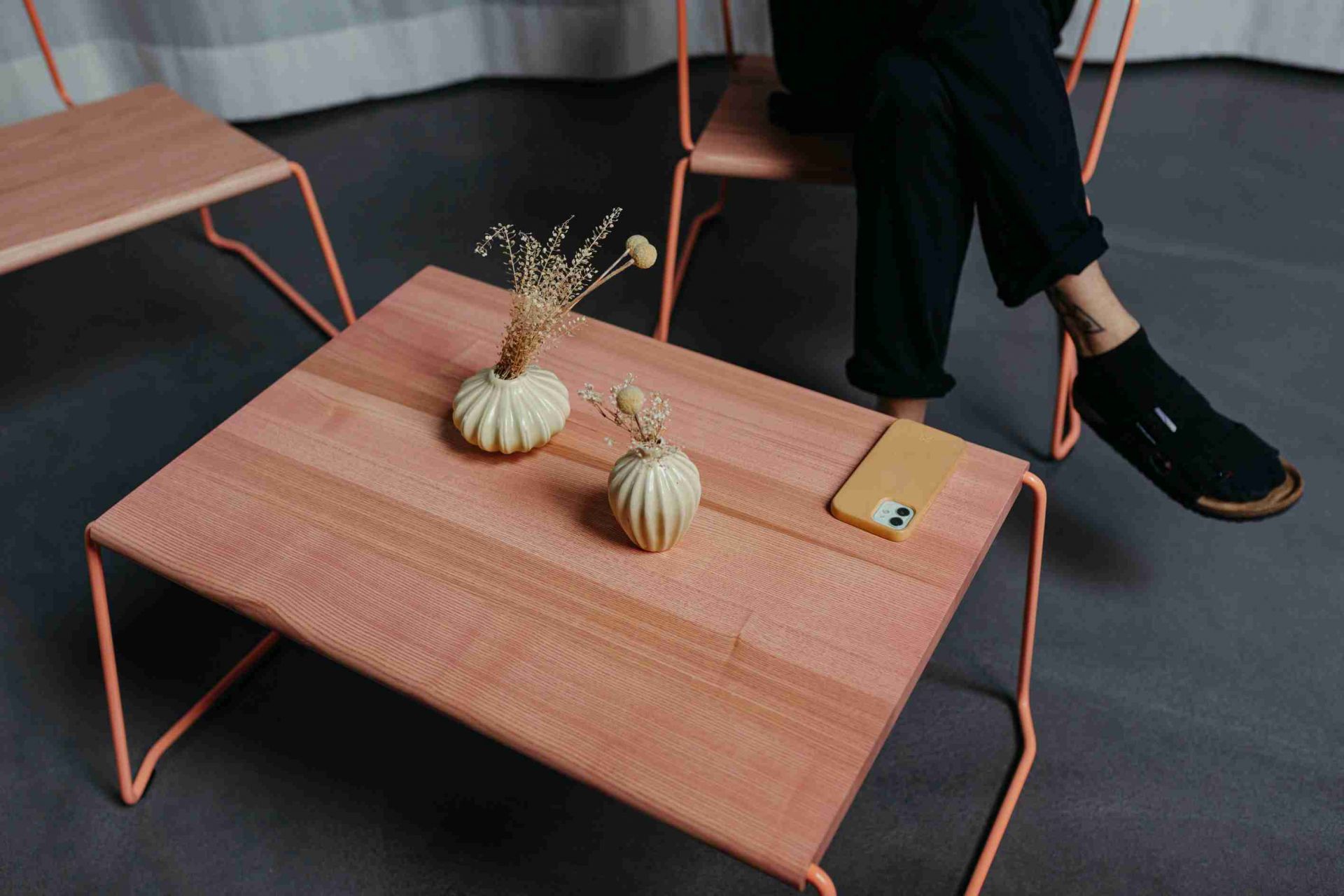 D:009 Coffeetable Fuchs & Habicht aus Holz mit orangefarbenem Gestell, dekoriert mit Vasen und Handy.