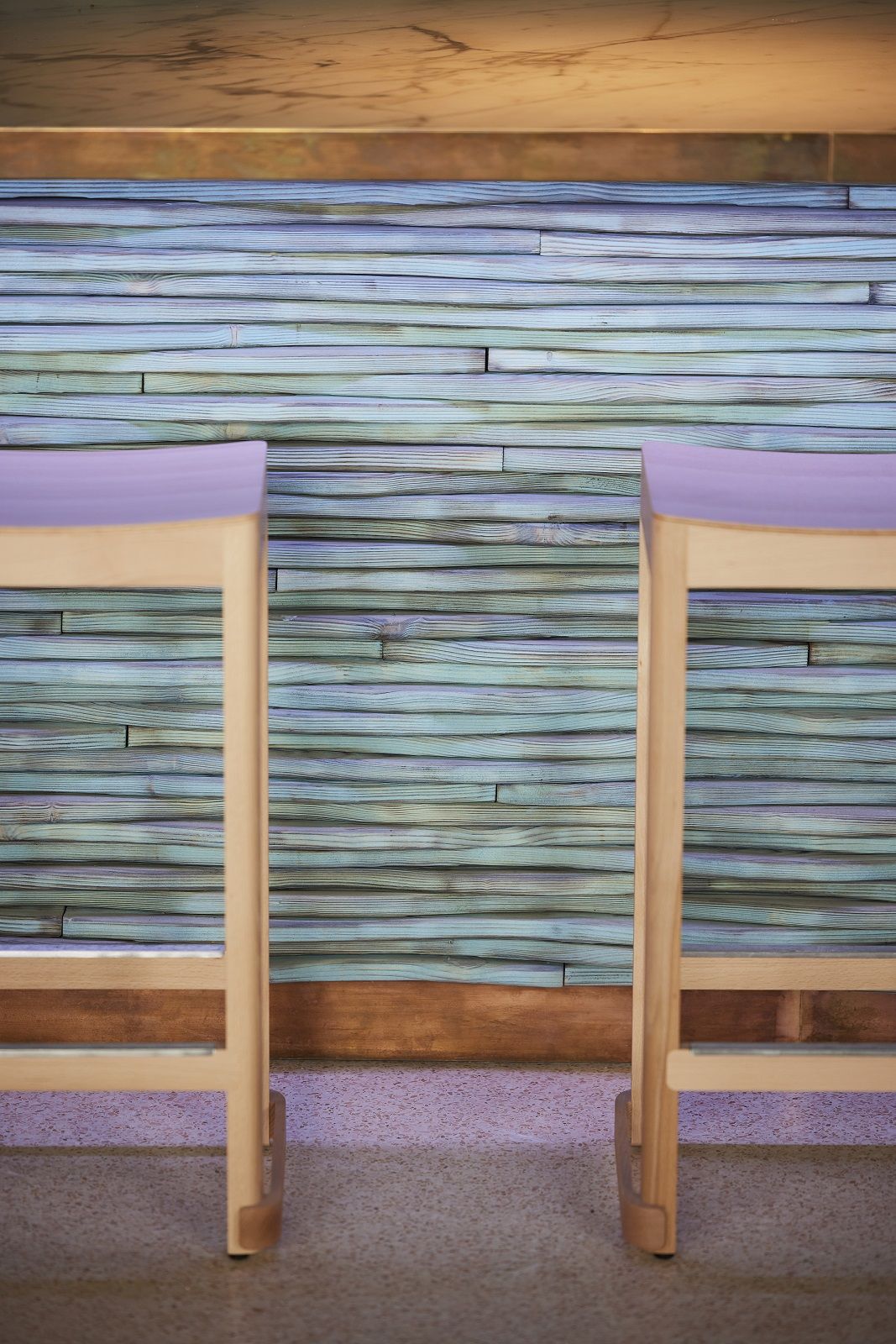 Zwei Atelier Bar Stool Barhocker von Artek mit hellem Holzgestell und lila Sitzfläche.