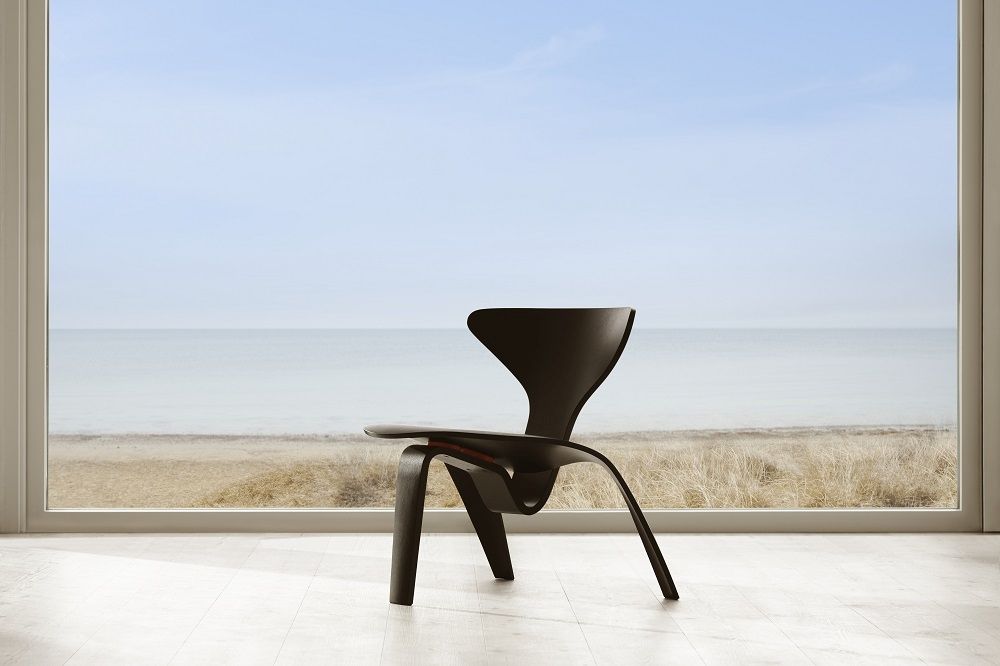 Schwarzer PK0 A™ Chair Stuhl von Fritz Hansen vor einem Fenster mit Meerblick.