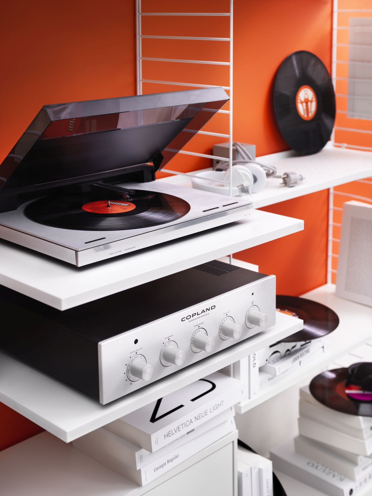 Weißes String Regalsystem mit Schallplattenspieler, Verstärker und Schallplatten. Modernes Wandregal für Wohnzimmer und Musikliebhaber.