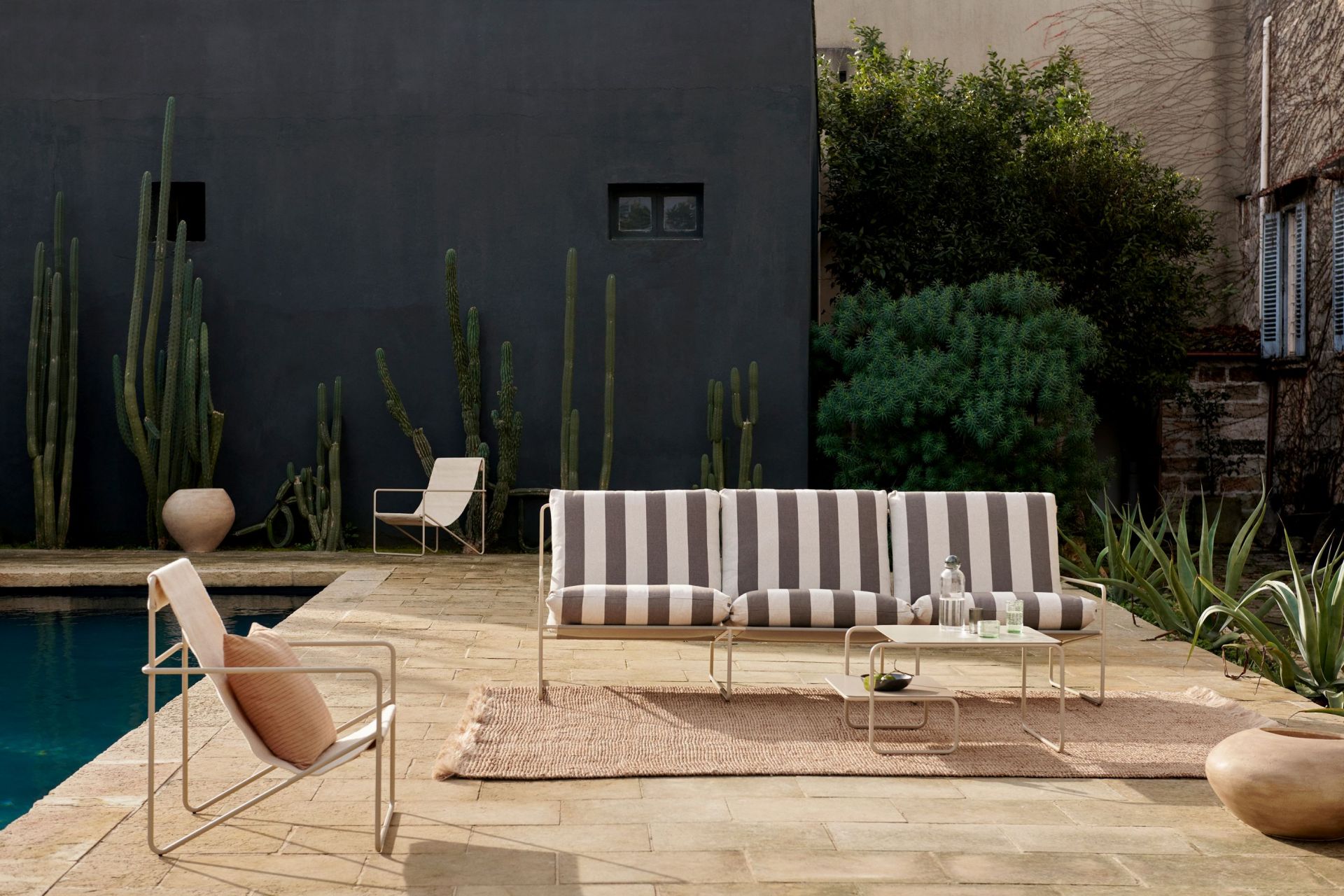 Desert 3-Sitzer Outdoor Sofa von Ferm Living mit Streifenmuster und Cashmere-Gestell in Gartenlandschaft.