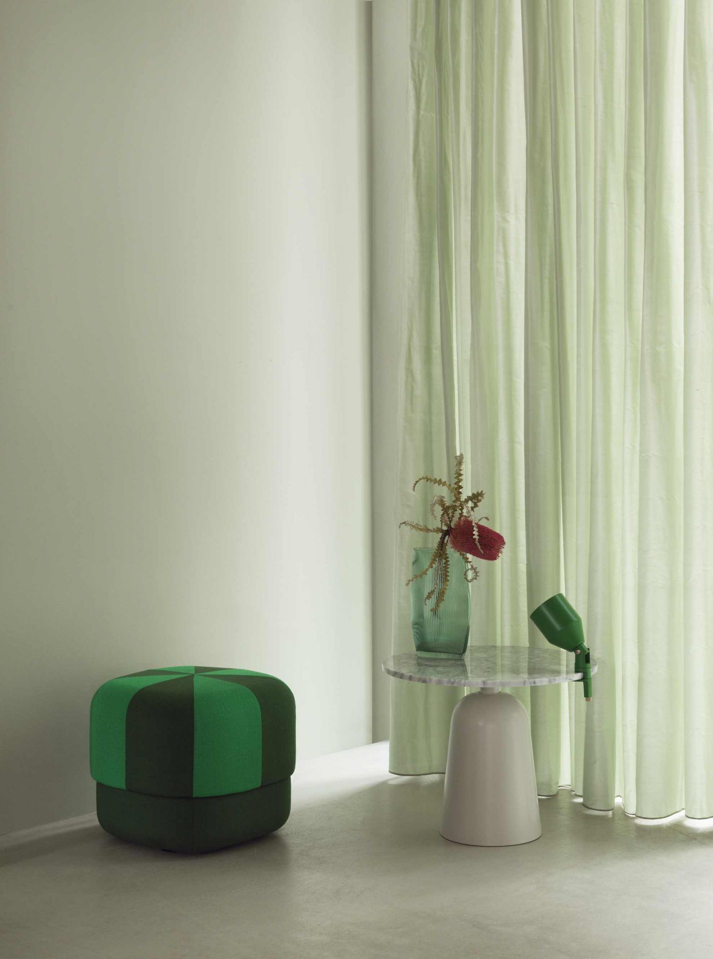 Normann Copenhagen Turn Table Marmor Tisch mit grüner Vase und Hocker in pastellfarbenem Raum.