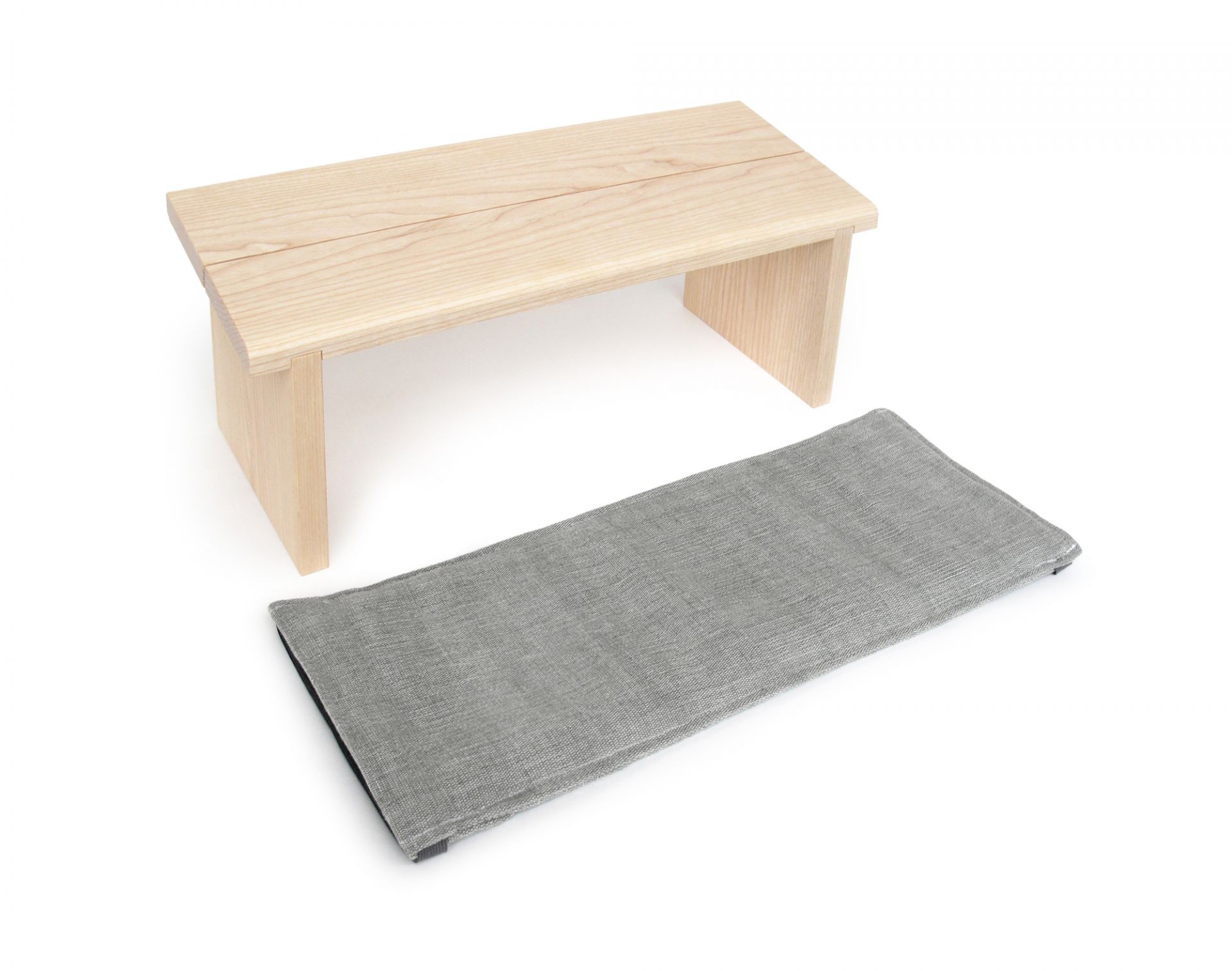 Auflage für Meditationsbank: Graue Meditationskissen-Auflage neben einer hellen Holzbank für entspanntes Sitzen.