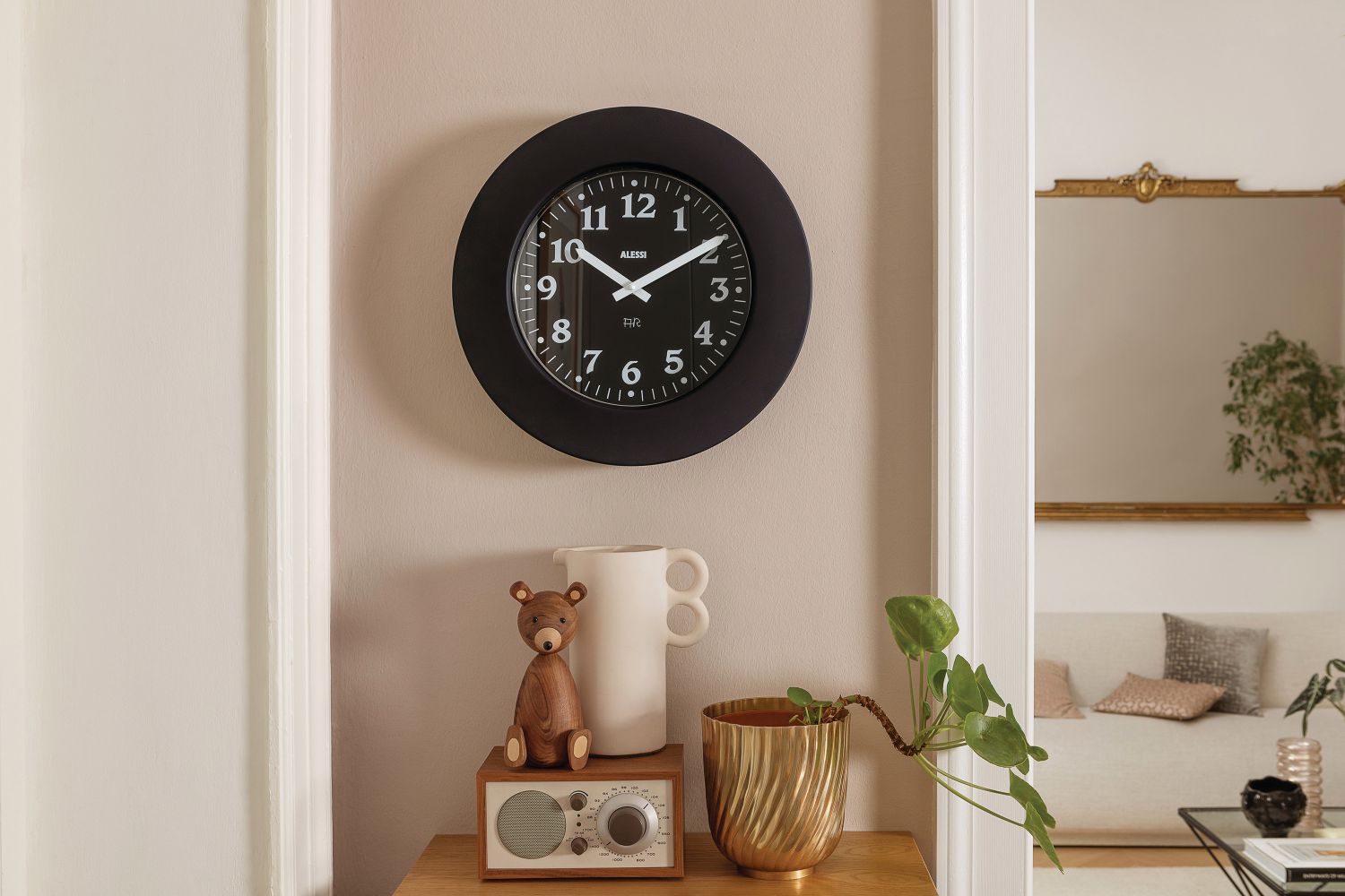 Schwarze Alessi Wanduhr "Momento 11 B" an der Wand, modernes Design für Wohnzimmer und Küche.