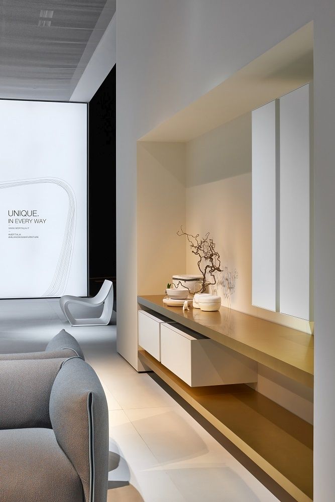 Grauer Sessel und weißer Sessel im Hintergrund. MDF Italia Möbel und Inneneinrichtung.