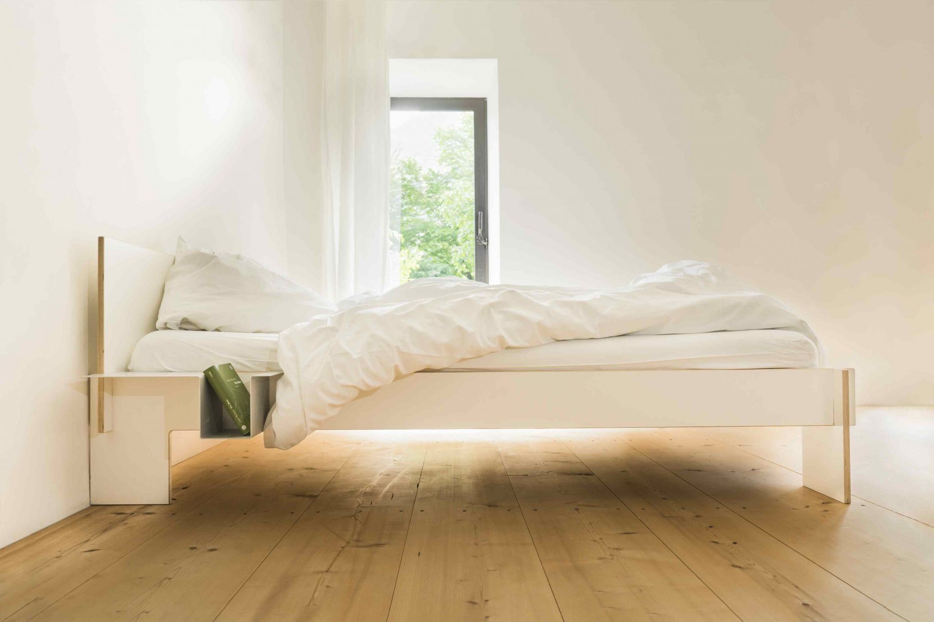 Weisses Siebenschläfer Bett von Moormann mit Kopfteil, 160 cm breit, im hellen Schlafzimmer. Modernes Design.