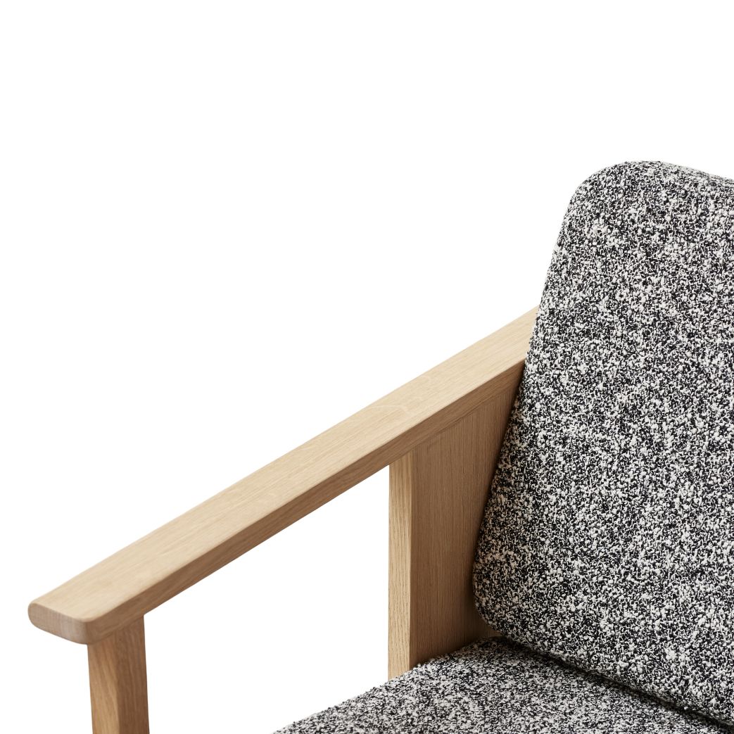 Detailaufnahme: Form & Refine Block Lounge Sessel mit weiß geöltem Holzrahmen und gemustertem Stoff.