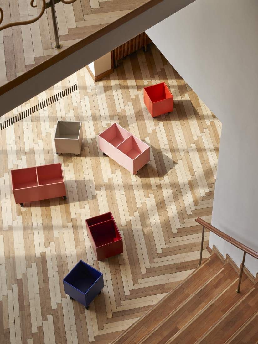 Ansicht von oben: Mehrere farbige Colour Box Aufbewahrungsboxen auf Rollen auf einem Holzboden.