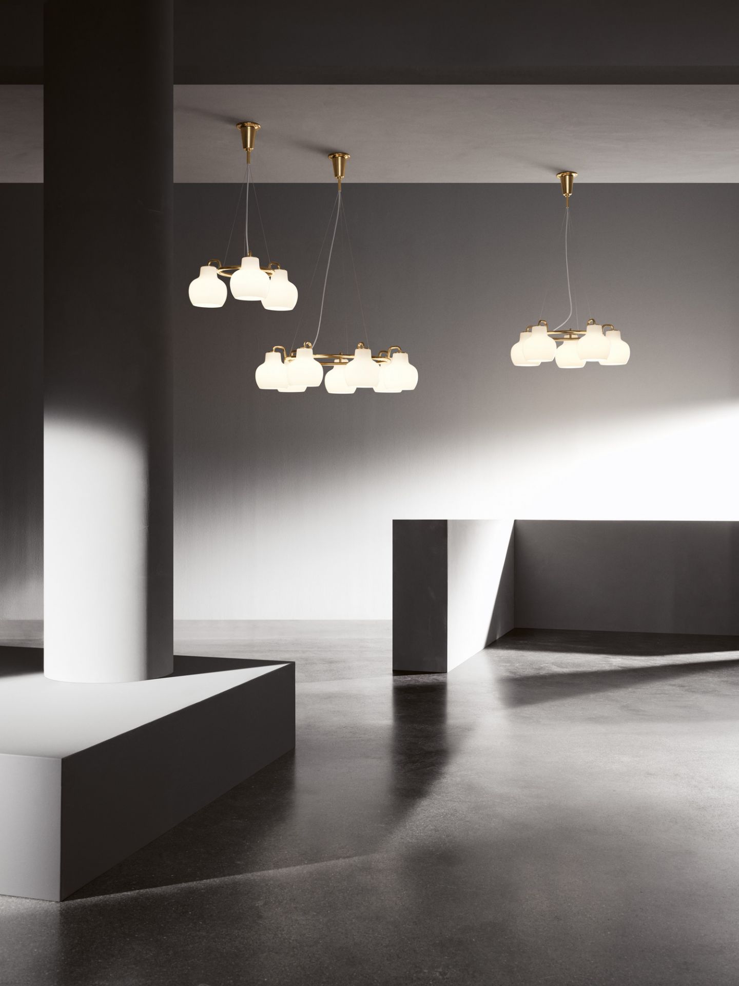 Drei VL Ring Crown Pendelleuchten von Louis Poulsen mit Messingdetails und opalweißem Glas in modernem Raum.