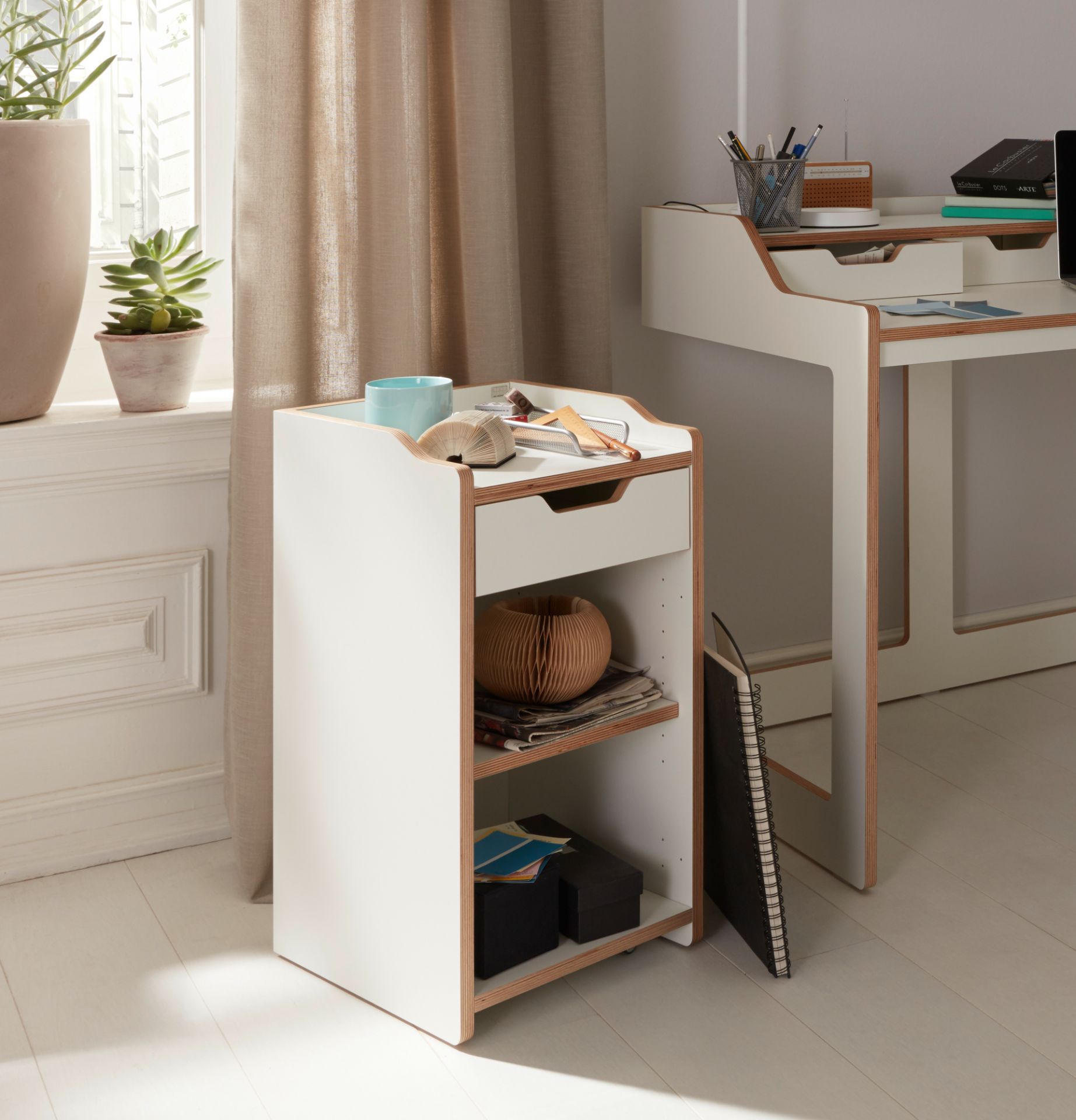 Weißer Rollcontainer von Müller Möbelwerkstätten mit Schublade und Regalen im hellen Raum.