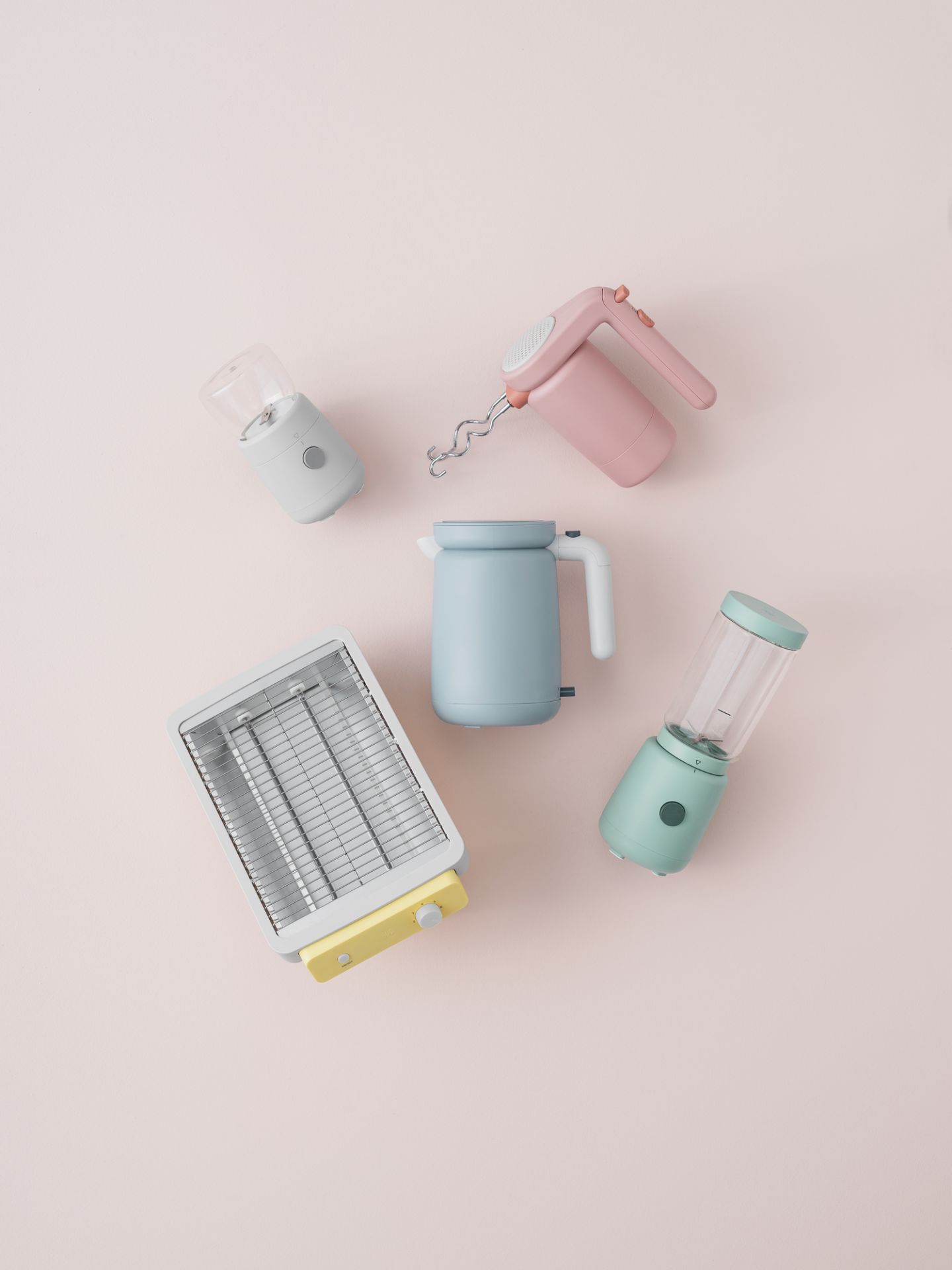 Hellrosa RIG TIG by Stelton Handmixer, Toaster, Wasserkocher und Mini-Mixer auf rosa Hintergrund.