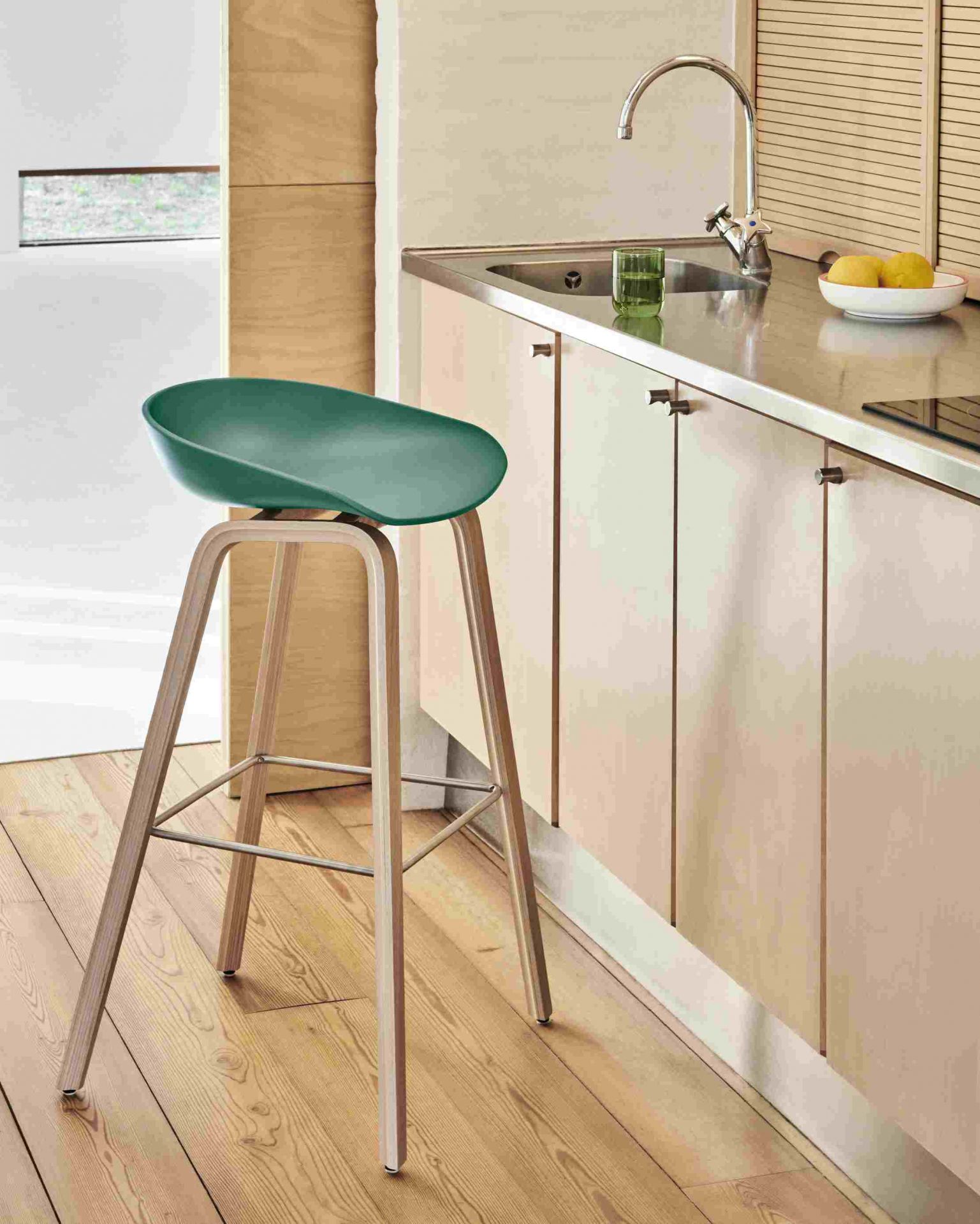 About a Stool AAS32 Barhocker in Azure Blue mit Holzbeinen vor einer Küchenzeile.