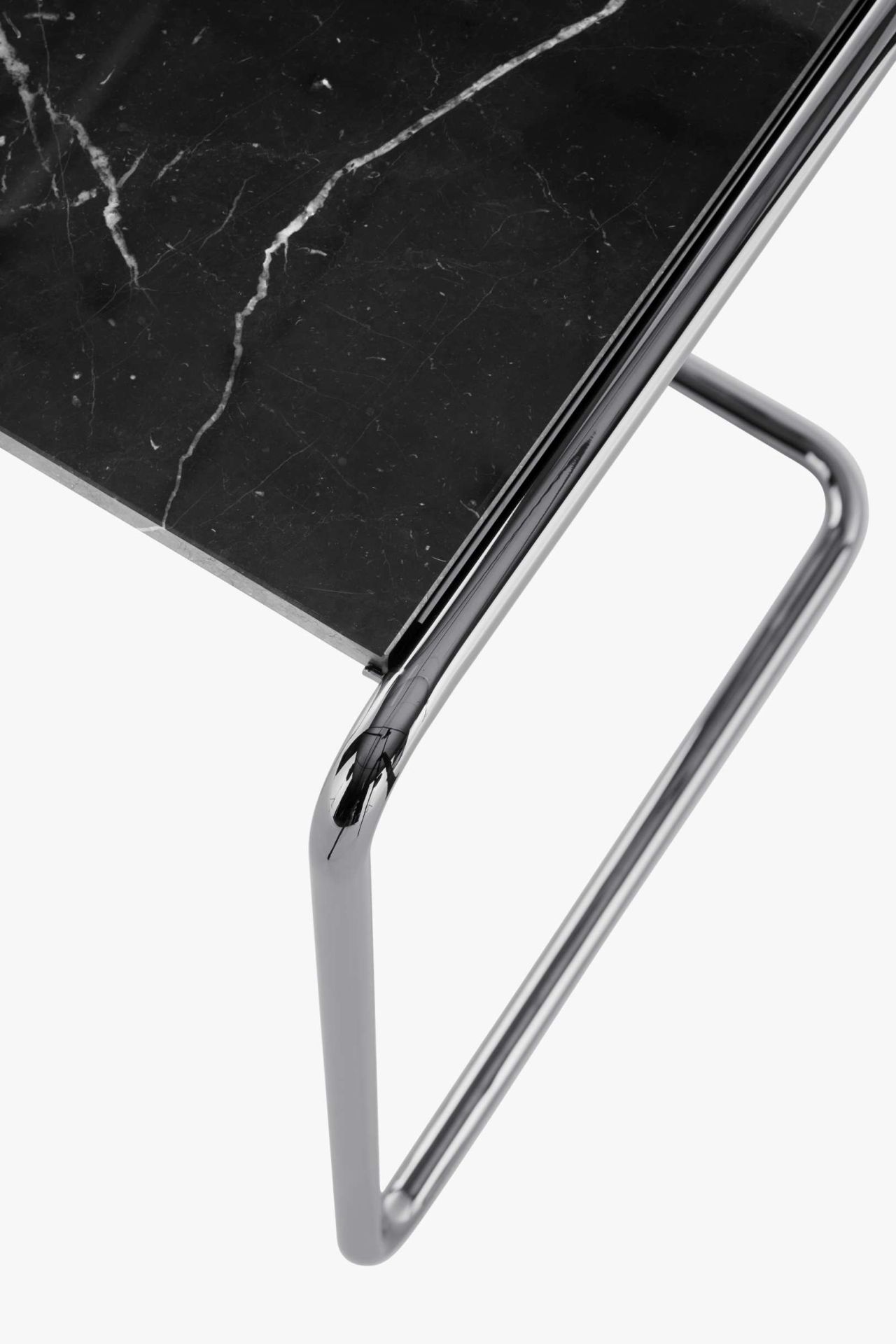 Detailaufnahme des Thonet B97 Beistelltisches mit schwarzer Marmorplatte und verchromtem Stahlrohrgestell.