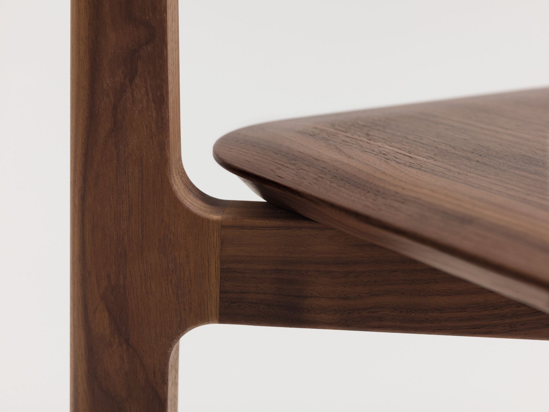 Detailaufnahme: 1.3 Chair Holzstuhl aus Amerikanischem Nussbaum, Fokus auf Sitzfläche und Bein.