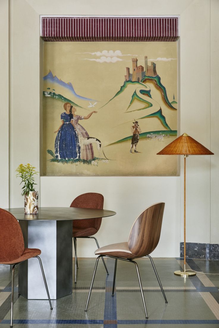 Epic Esstisch rund von Gubi in Misty Gray Stahl mit Stühlen und Dekoration.