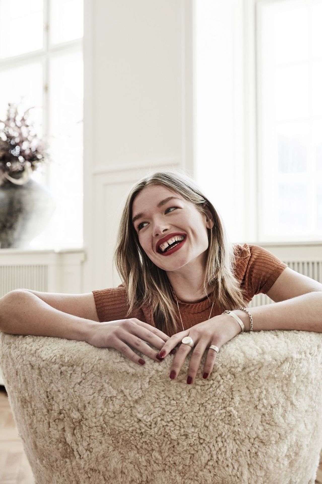 Frau entspannt im Little Petra Sessel von Andtradition, Bezug Karakorum, Gestell Walnuss.