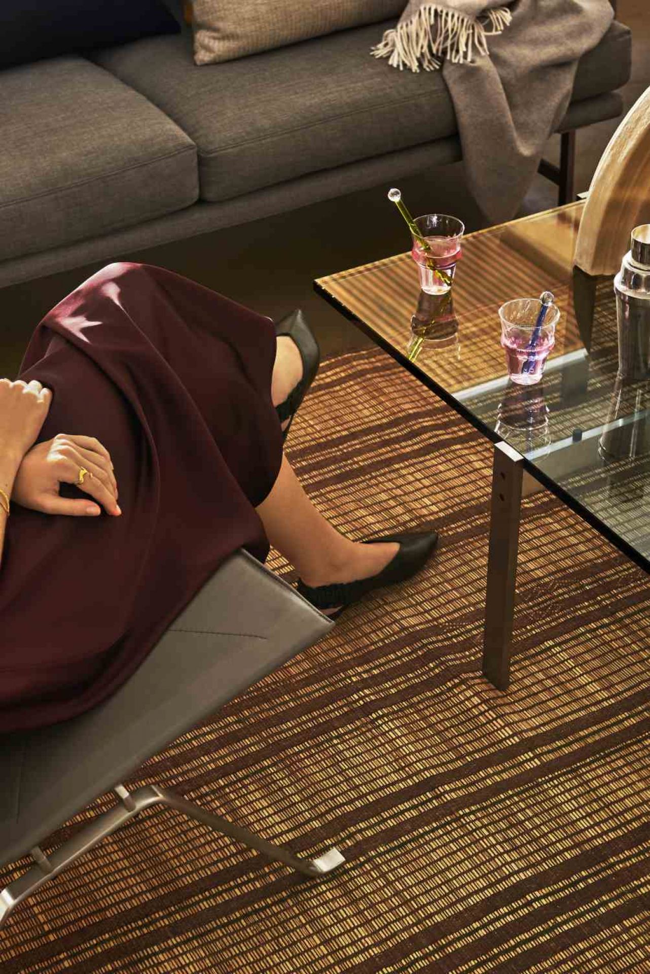 Frau entspannt mit Getränken auf dem PK65 Couchtisch von Fritz Hansen im Wohnzimmer.