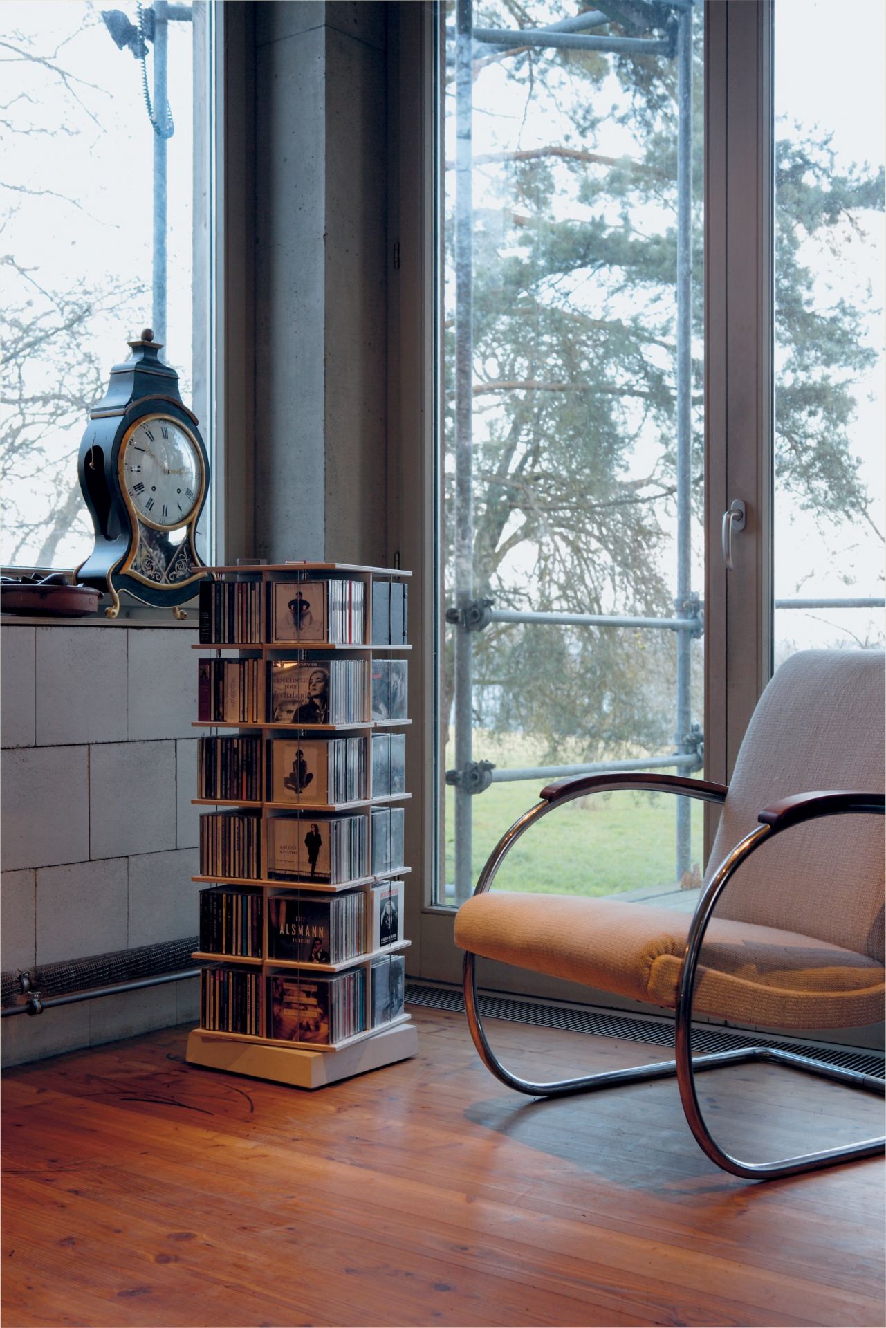 Musikstapler CD-Regal von Nils Holger Moormann, gefüllt mit CDs, neben einem Sessel.