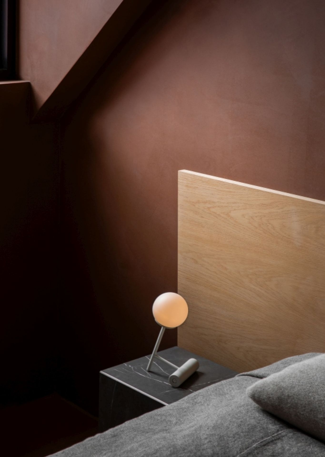 Nahaufnahme der Audo Phare LED Tischleuchte in Schwarz auf einem Nachttisch.