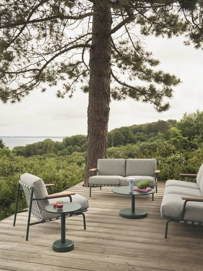 Muuto Settle Outdoor Sofa 3-Sitzer auf Holzterrasse mit Blick auf die Natur.