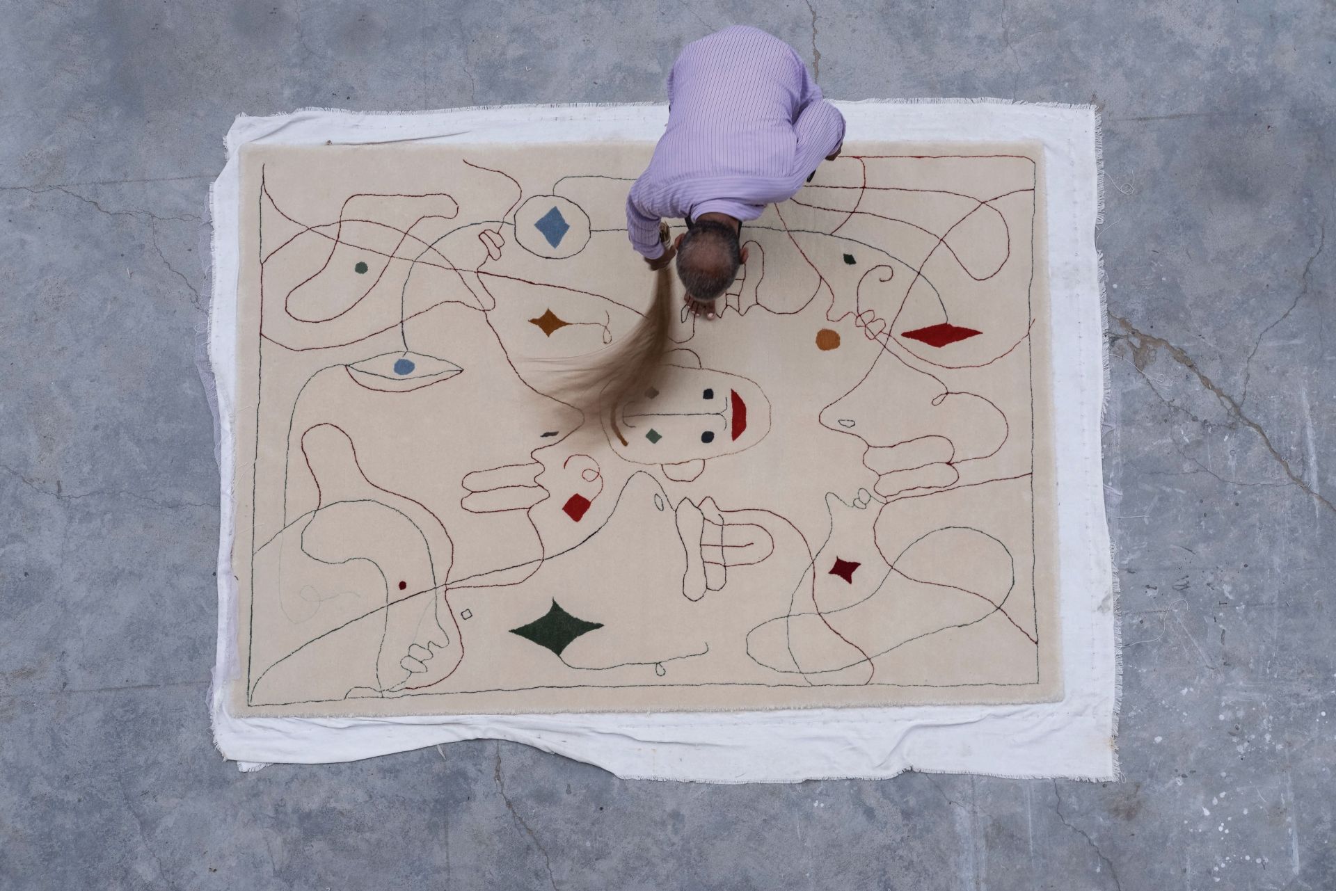 Mann reinigt Nanimarquina Silhouette Outdoor Teppich 200x300 cm. Moderner Design Teppich für den Außenbereich.