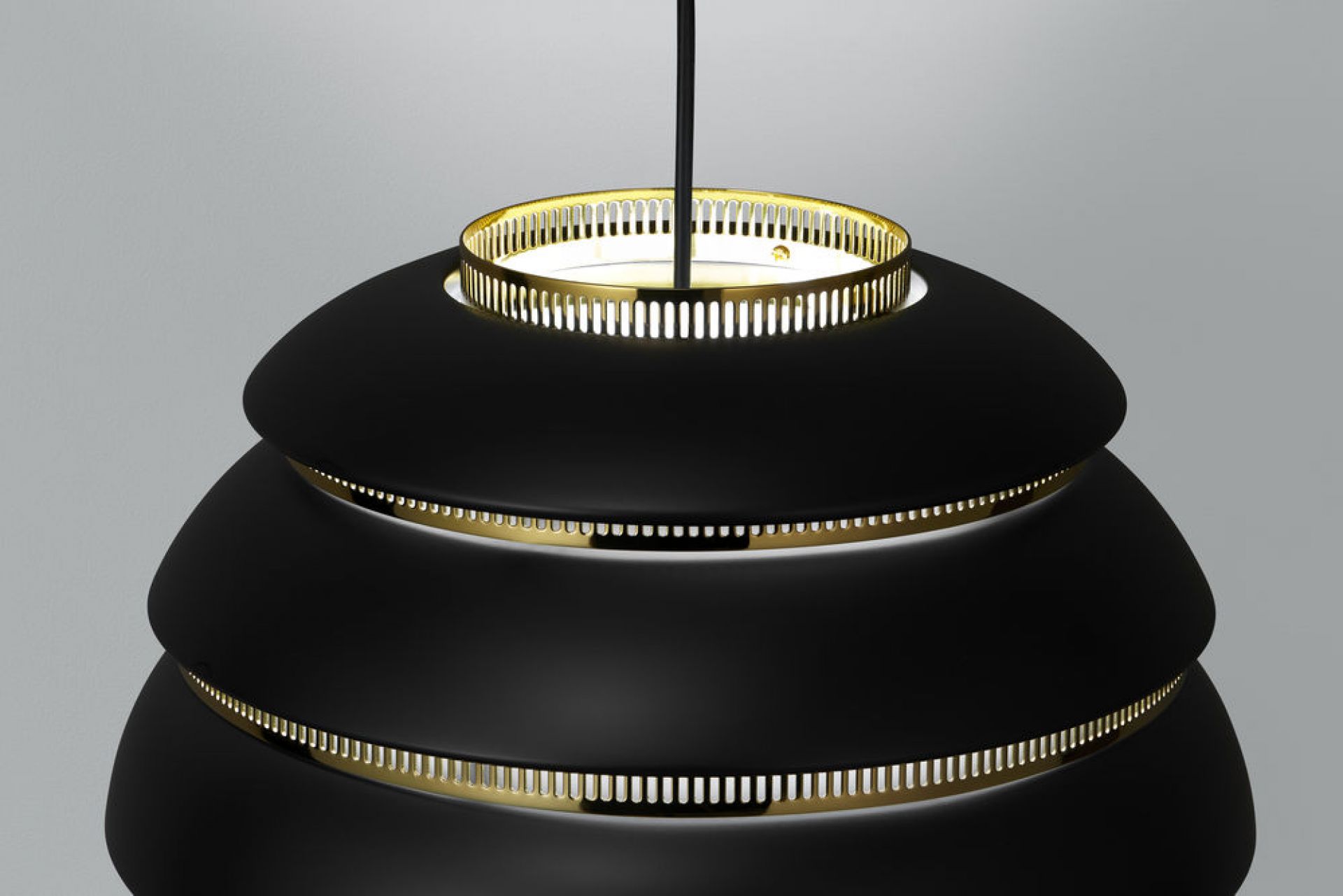 Nahaufnahme der schwarzen Artek A331 Beehive Hängeleuchte mit goldenen Akzenten.
