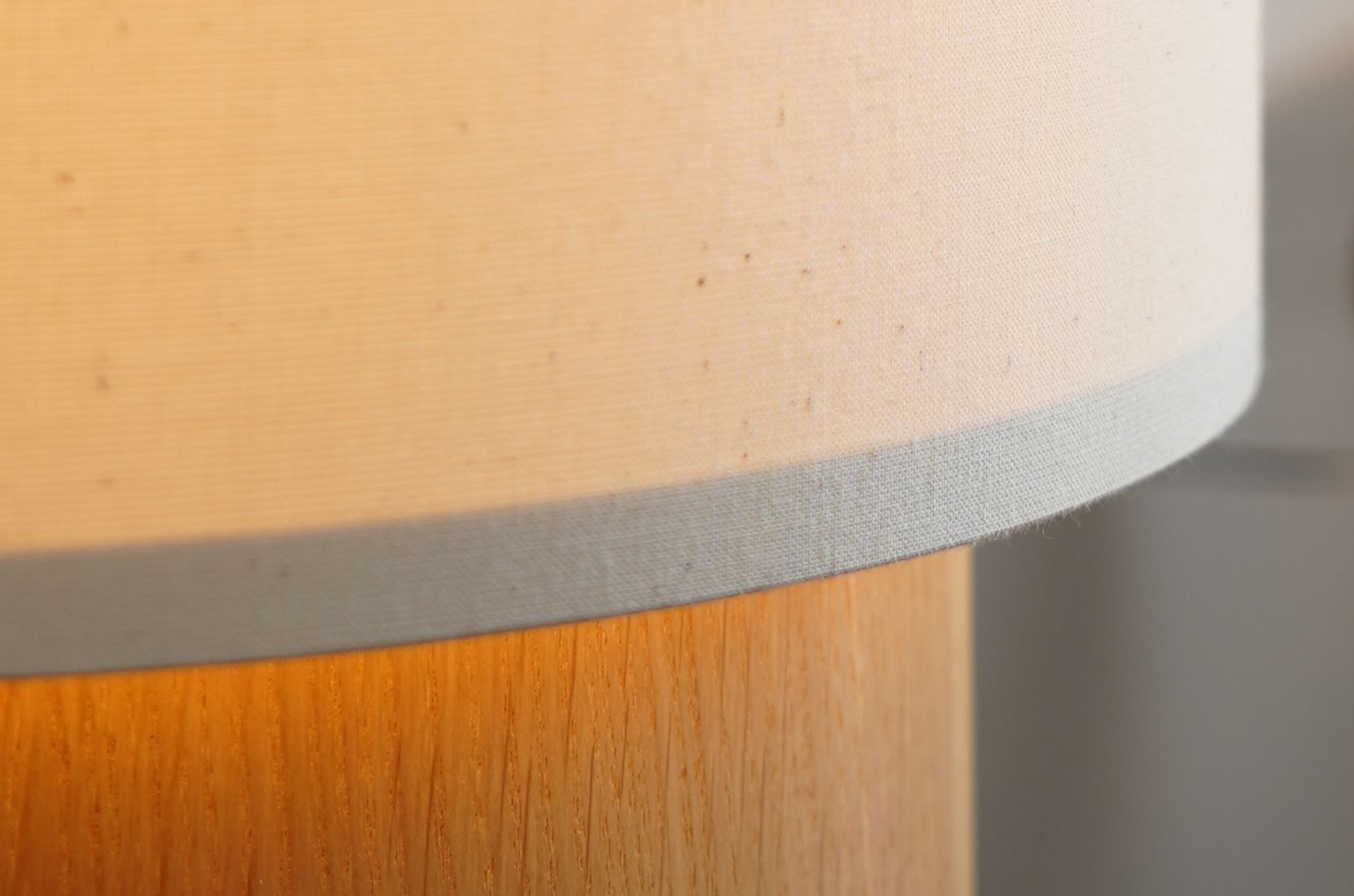 Detailaufnahme der Hiro Stehleuchte von Maigrau mit hellem Lampenschirm und Holzfuß.