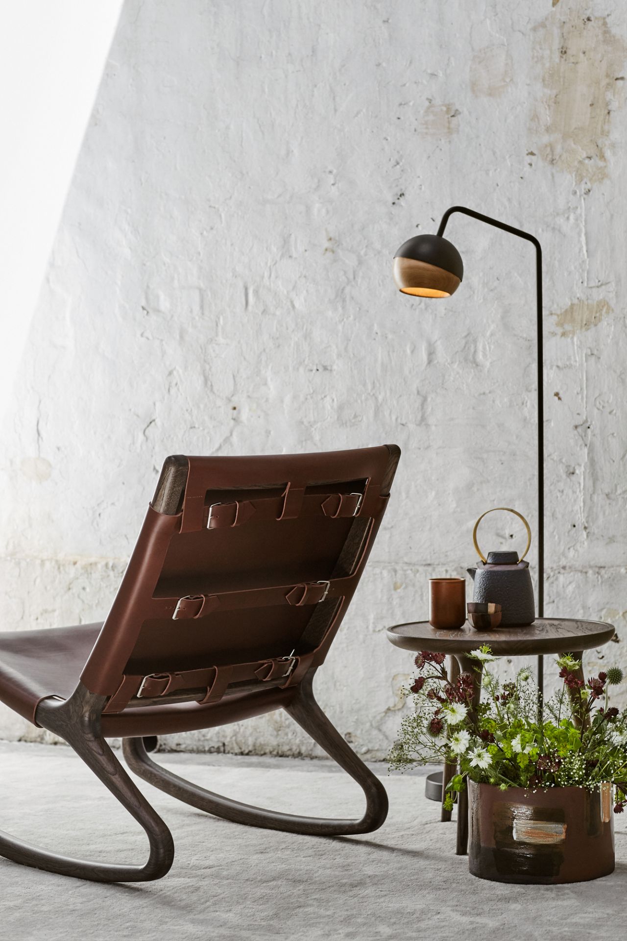 Ray Stehleuchte von Mater neben Sessel und Tisch mit Teekanne in stilvollem Ambiente.